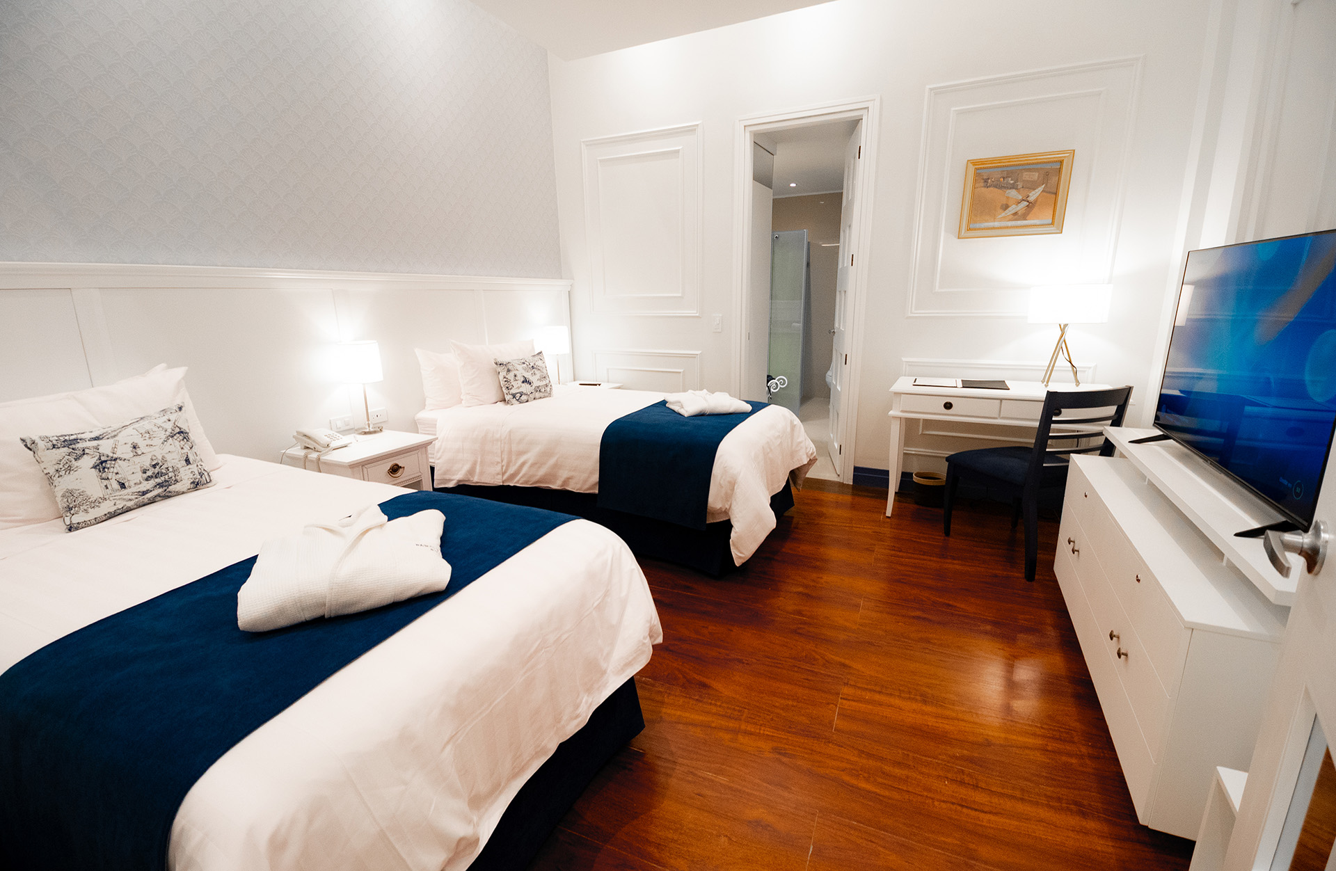 Habitación Confort Suites W1 con dos camas individuales, televisión de pantalla plana y escritorio en el hotel Parc Royal Cuenca